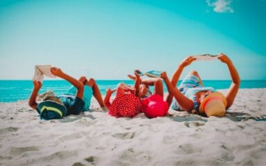 Familie beim Lesen am Strand.